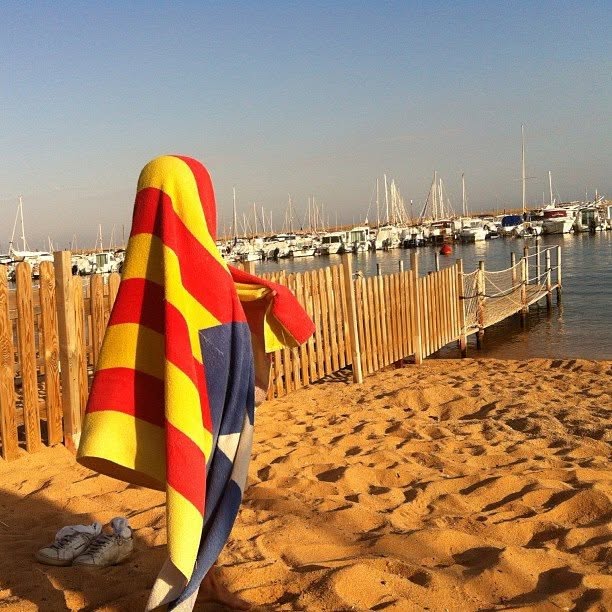 Ignasi davant d'un port, cobert amb una tovallola de colors